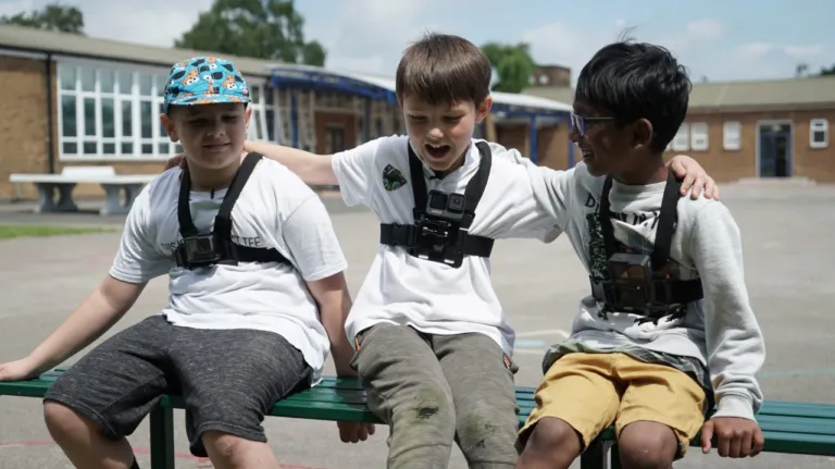 Three young boys outside together in a playground