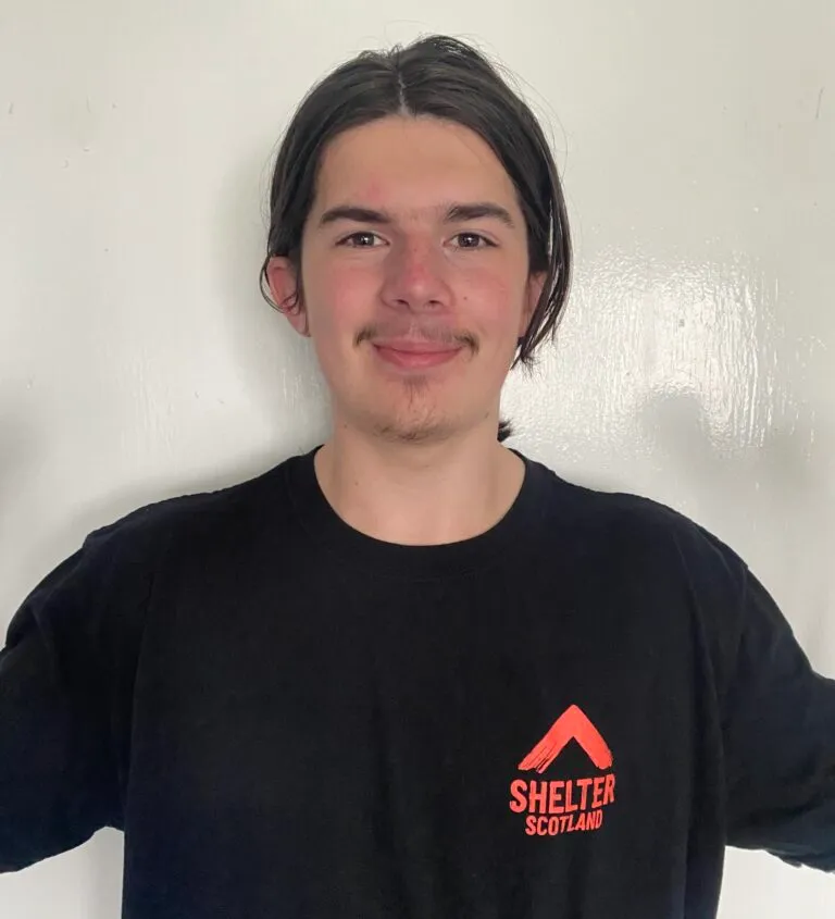 Photo of Josh smiling and wearing a Shelter branded T-shirt
