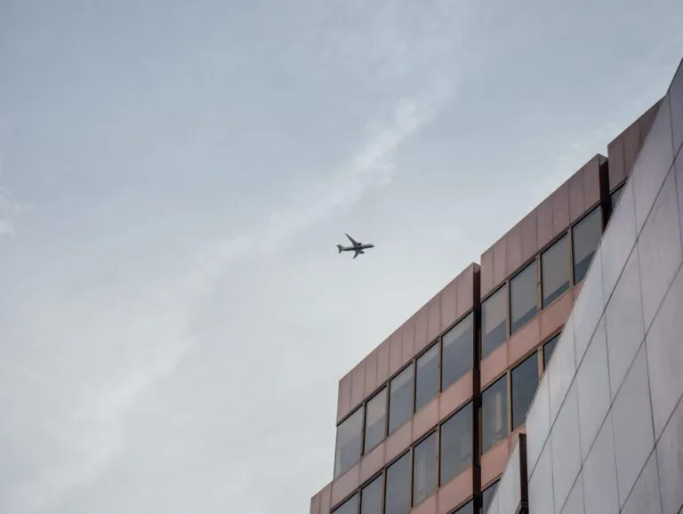 A plan flies over a mult-storey building