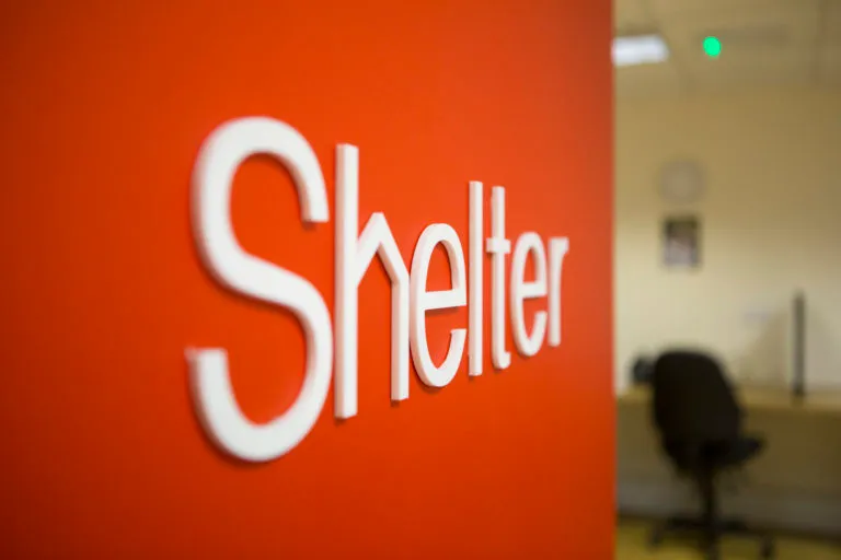 A Shelter logo on a red wall at a Shelter hub