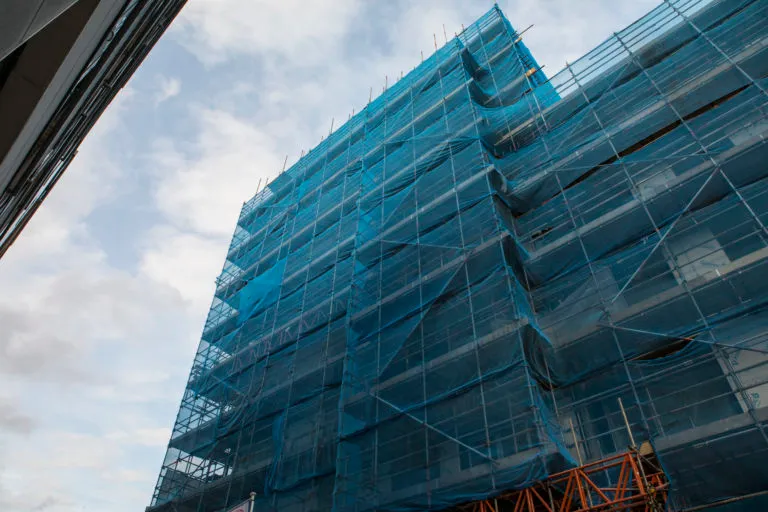 A photo of a high-rise building covered in scaffolding