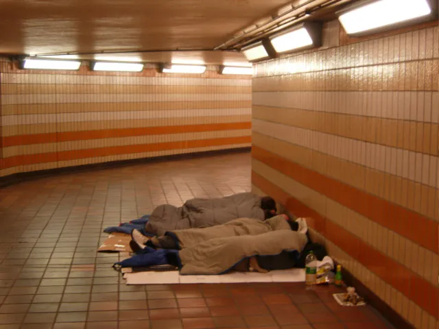People sleeping rough in sleeping bags in an underground train tunnel