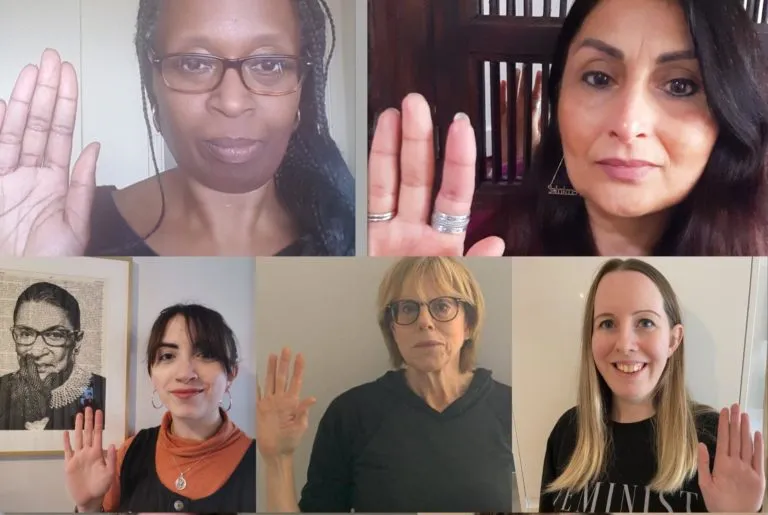 Screenshot of a Zoom call with lots of women holding their hands up