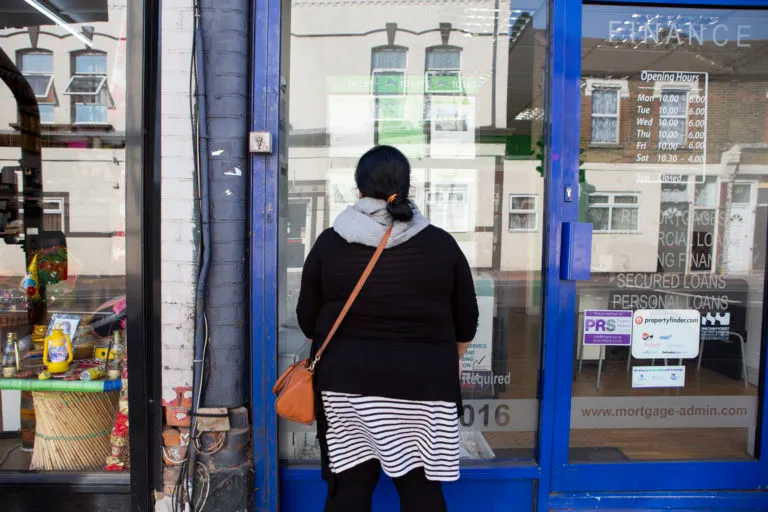 Woman looking in a letting agent's window