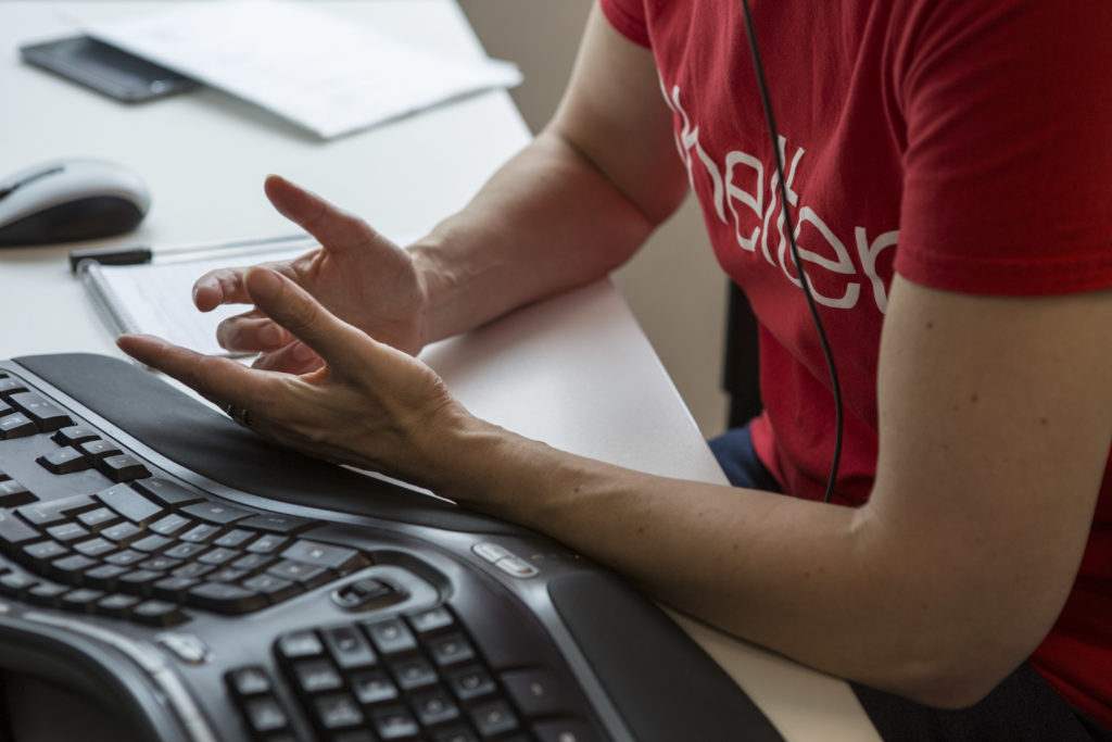 A helpline adviser's hands, as she talks on the phone in Shelter's Sheffield Hub office.