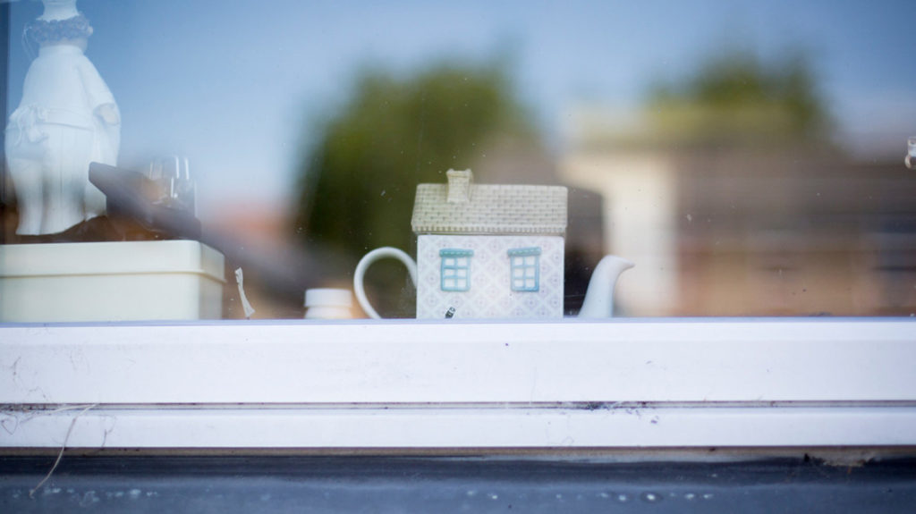 House shaped tea pot in a window