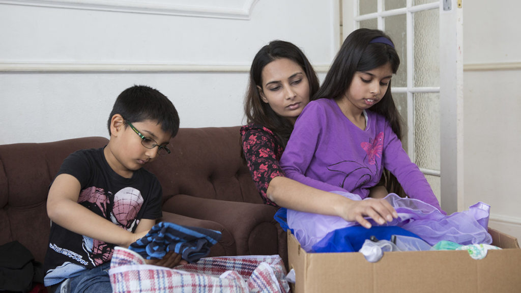 A family pack up a box of their possessions