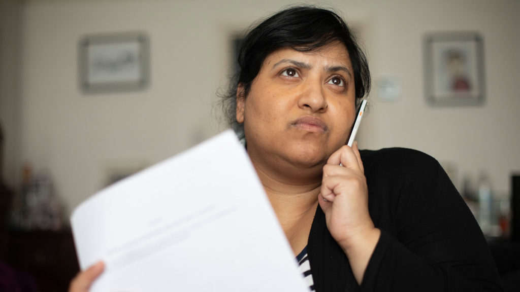 Woman looks concerned as she looks at housing documentation
