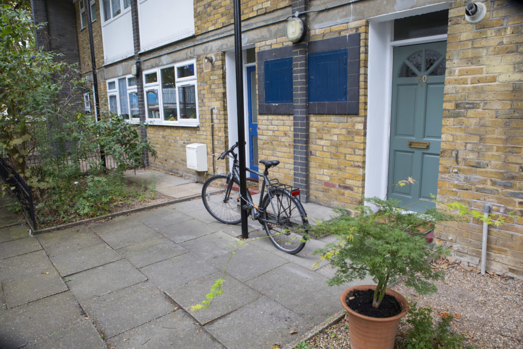The outside of a council house with a bicycle lent against it