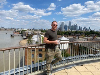 Lyle, on a rooftop with the London skyline in the background