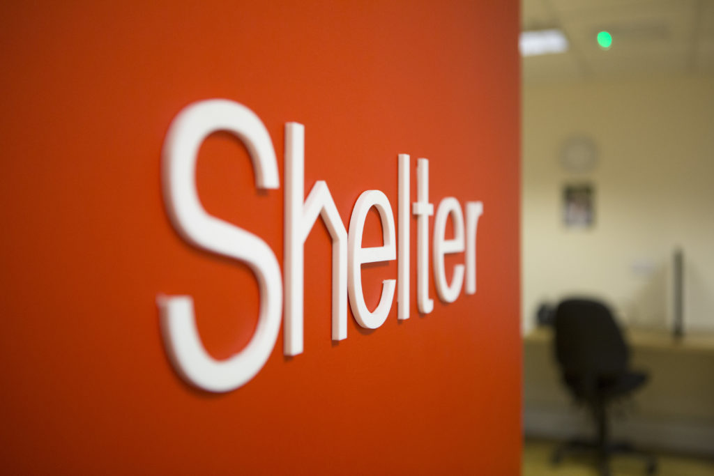 A Shelter logo on a red wall at a Shelter hub