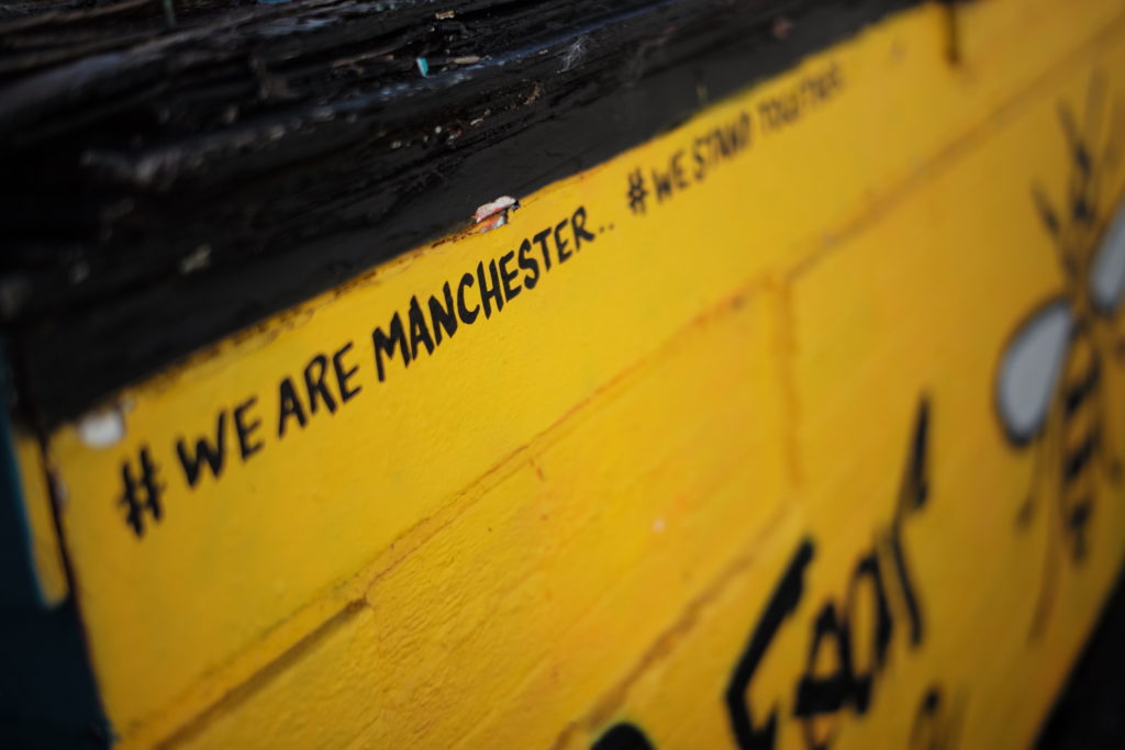 Street art which is yellow and says We are Manchester