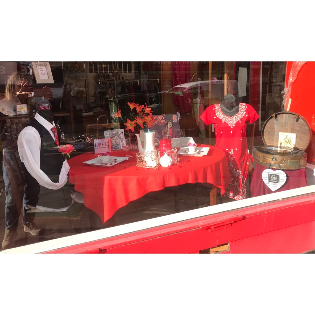 Two mannequins dressed up by volunteer Kate for Valentines Day at a window display at a Shelter shop in Bristol